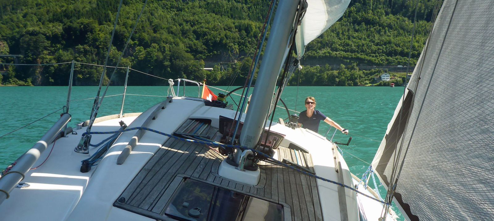 Blick vom Deck einer Yacht über das Grosssegel auf den See