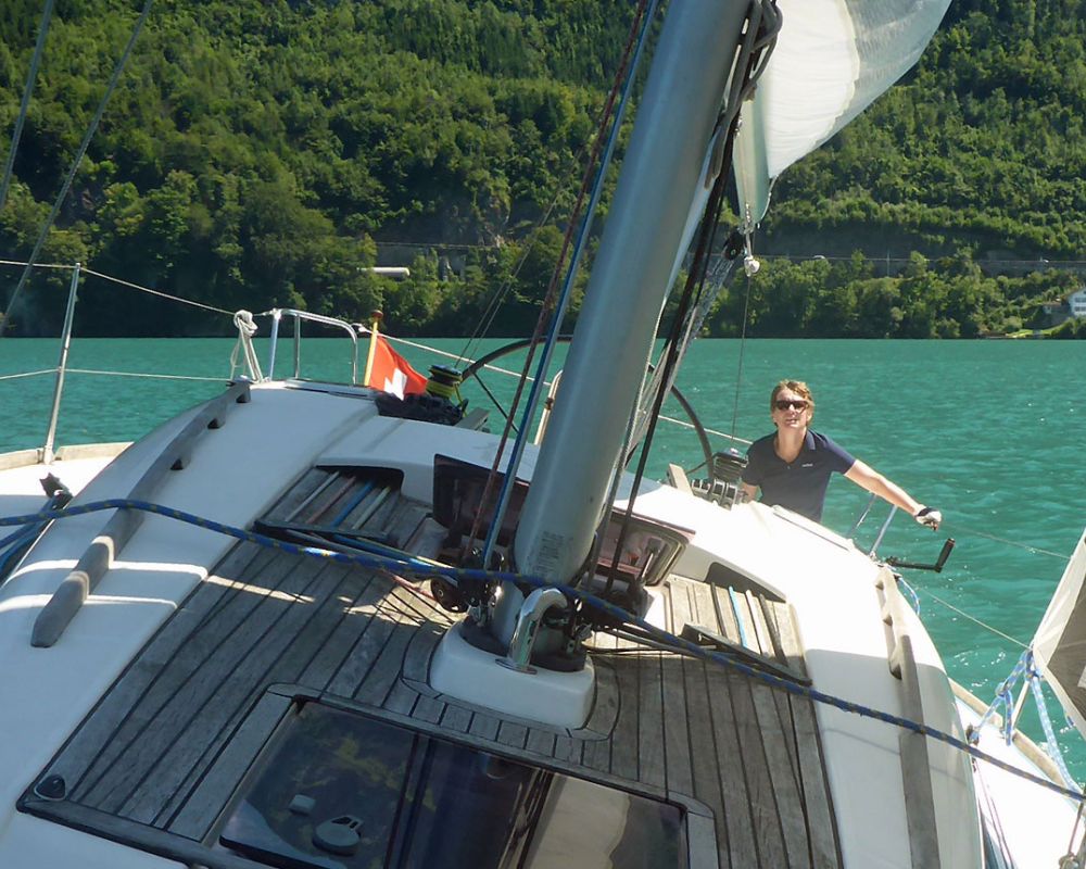 Blick vom Deck einer Yacht über das Grosssegel auf den See